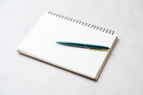 ペンとノートが机に置かれた写真